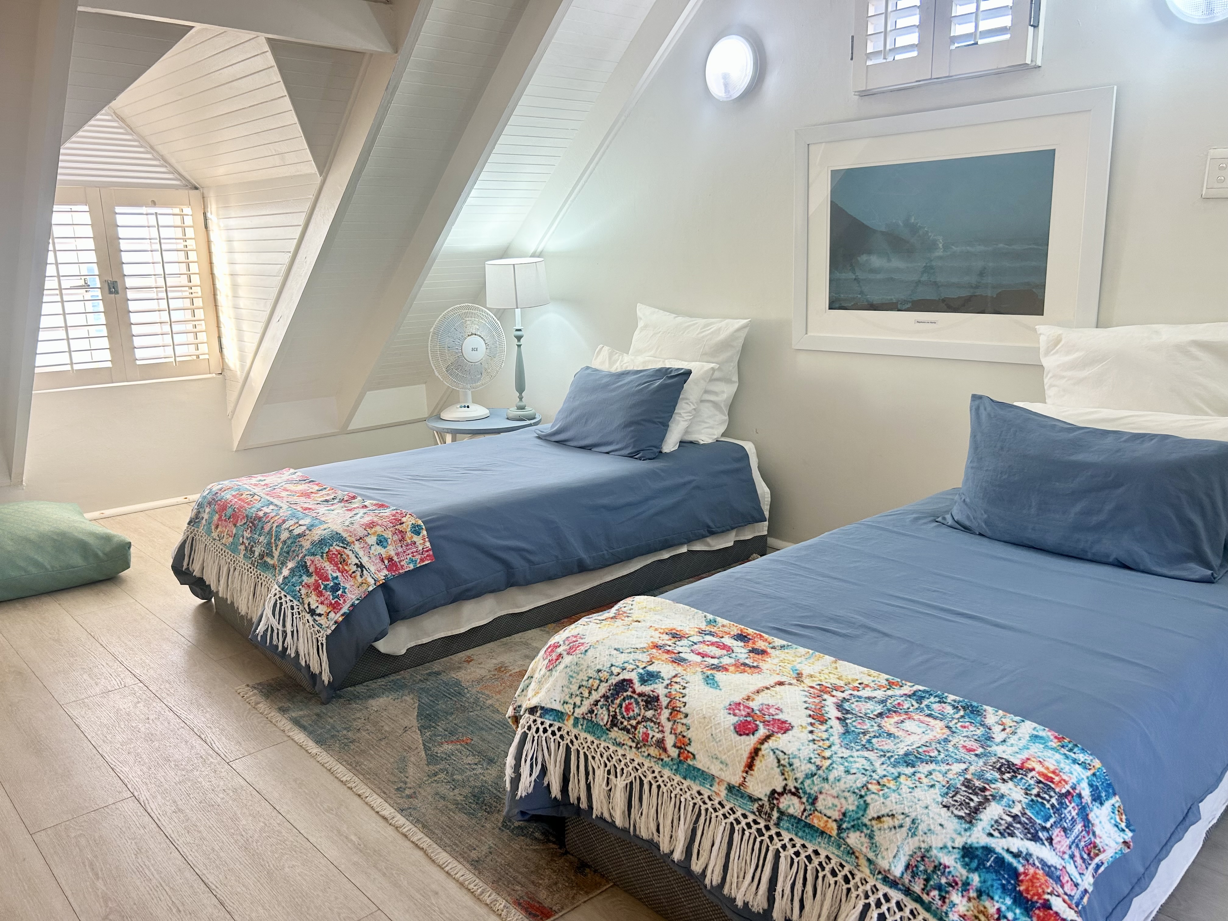 Main bedroom at The Beach Cottage with soft natural light and coastal views